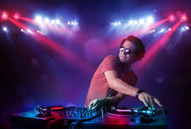 Teenager dj mixing records in front of a crowd on stage stock photo