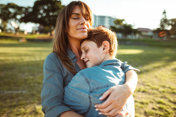 teenager embraced with mom consoling her son teenager embraced with mom consoling her son mother and teenage son stock pictures, royalty-free photos & images