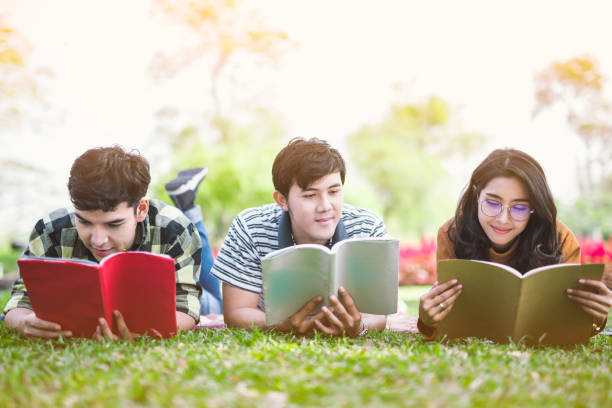 tiener leesboek in park. onderwijs door lezen. - hogeschool rood samen stockfoto's en -beelden