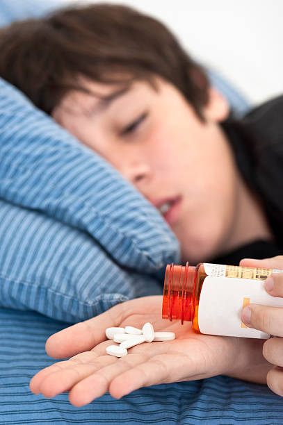 Teenager taking prescription drugs Child lying in bed after taking prescription drugs xanax pill stock pictures, royalty-free photos & images