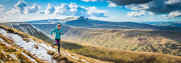 teenager trail running along mountain path brecon beacons panorama wales - train travel stockfoto's en -beelden
