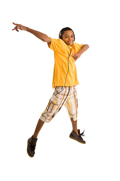 Teenager wearing headset and jumping arms outstretched stock photo