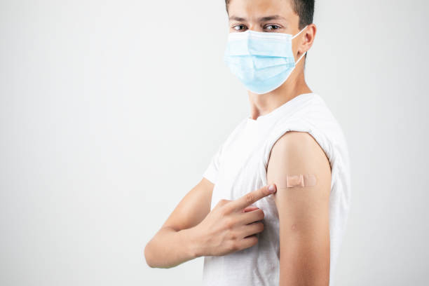 Teenager with a protective mask after vaccination - Covid 19 vaccination Teenager with a protective mask after vaccination - Covid 19 vaccination lepro stock pictures, royalty-free photos & images