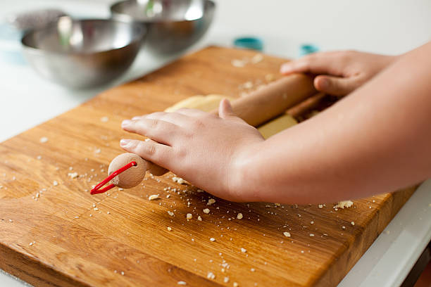 Teenager's Hand Flattening Dough with Rolling Pin stock photo
