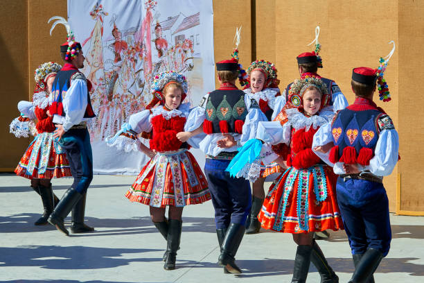 Teenagers in folk dresses dance folk dance after parade during the Ride of the Kings folklore festival in Vlcnov, South Moravia, Czech Republic Vlcnov, Czech Republic - May 28, 2017: Boys and girls in folk dresses dance folk dance after parade during the Ride of the Kings folklore festival in Vlcnov, South Moravia, Czech Republic czech culture stock pictures, royalty-free photos & images