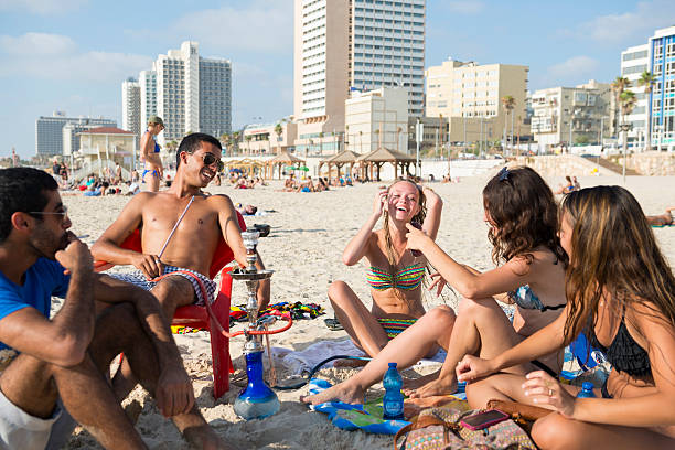 Tel Aviv summer beach lifestyle Tel Aviv, Israel - July 17, 2013: Young Israelis enjoy a summer day at the beach in Tel Aviv, smoking a water pipe and drinking water under the hot sun. hot middle eastern women stock pictures, royalty-free photos & images