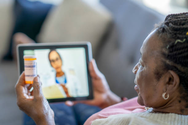 Telemedicine call between a senior woman and her doctor stock photo