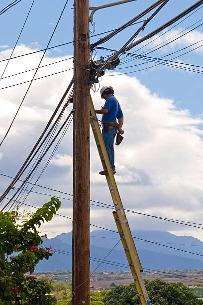 Telephone Repair Telephone Repair man installing to cable services to costumers telephone pole photos stock pictures, royalty-free photos & images
