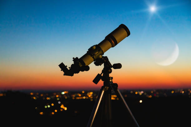 Telescope silhouette and night sky with city lights in the background. Telescope silhouette and night sky with city lights in the background. telescope stock pictures, royalty-free photos & images