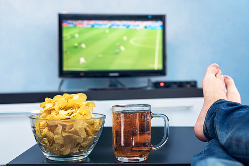 Tv Television Watching Football Match On Tv With Snacks And Alcohol Relax In Front Of The Tv A Fan Of Watching A Football Match Play Off A Plate Of Potato Chips And