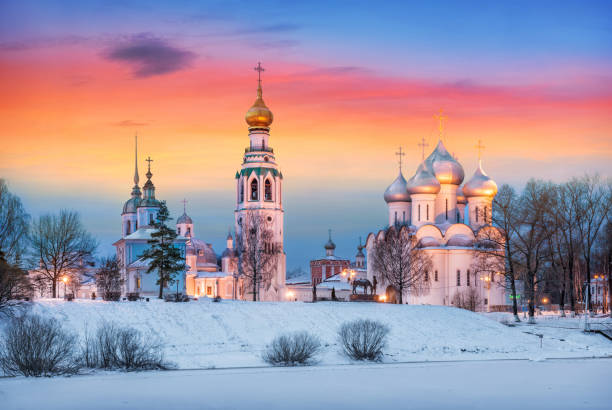 Temples of the Vologda Kremlin under a red-yellow dawn sky Temples of the Vologda Kremlin on a winter night under a red-yellow dawn sky. View across the Vologda river. bell tower tower stock pictures, royalty-free photos & images