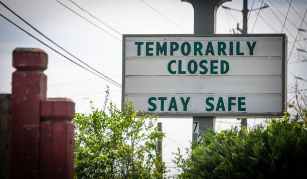 "Temporarily Closed, Stay Safe" Sign A sign tells customers that a business is temporarily closed due to the COVID-19 pandemic. closed stock pictures, royalty-free photos & images