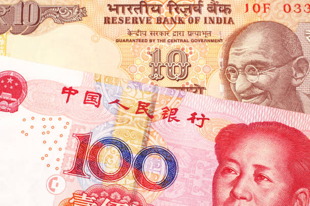 Ten Indian rupees with one hundred Chinese yuan stock photo