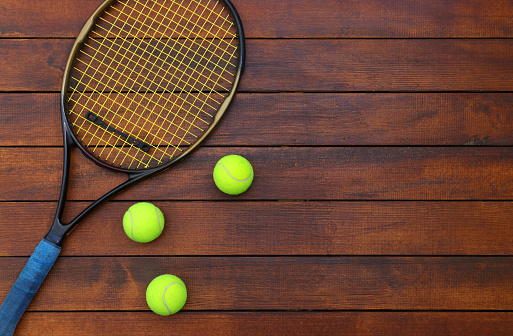 Tennis racket and ball on table with background players' doubles strategy on chalkboard and copy space.