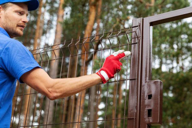 territory enclosure - worker installing metal fence territory enclosure - worker installing metal fence fence stock pictures, royalty-free photos & images