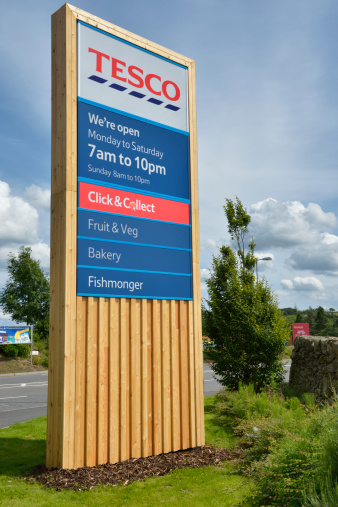 Castle Douglas, Scotland, UK - July 31, 2012: New wooden clad signage at the entrance to the Castle Douglas superstore. The store has recently been updated offering customers new products with new signs throughout the store to make them more inviting.