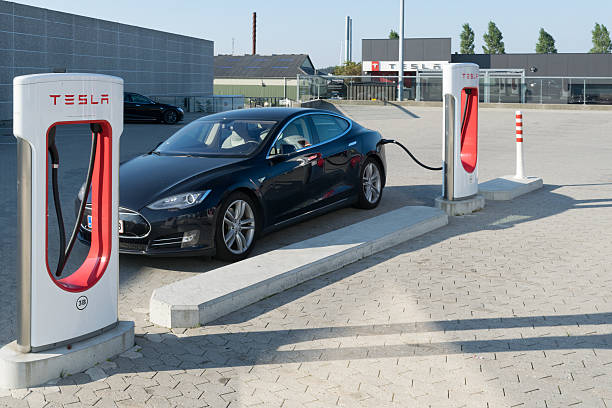Tesla car being charged atsupercharger charging station stock photo