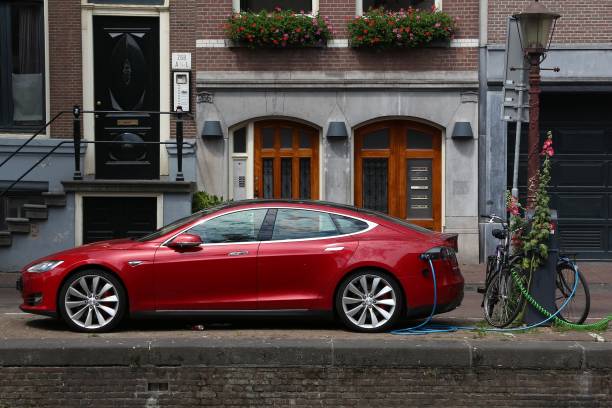 Tesla car Electric Tesla Model S car parked by the canal in Amsterdam. Netherlands has 528 registered cars per 1,000 inhabitants. tesla motors stock pictures, royalty-free photos & images
