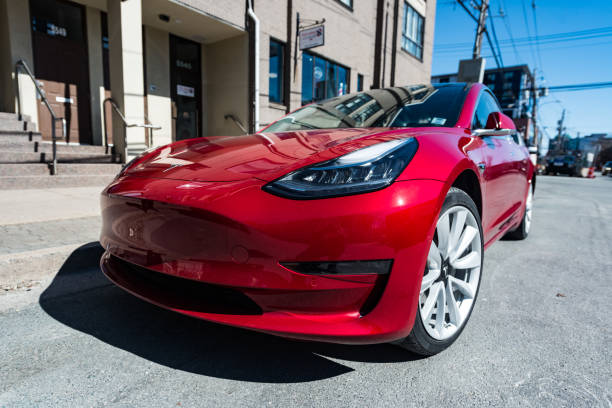 Tesla Model 3 March 26, 2019 - Halifax, Canada - A 2019 red Tesla Model 3 plug-in electric car parked on a city street in downtown Halifax. tesla motors stock pictures, royalty-free photos & images