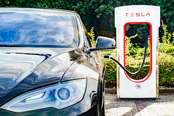 Tesla Model S electric car at a supercharger charging station stock photo