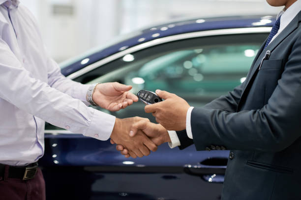 Test drive concept Salesman giving car keys to customer and shaking his hand land vehicle stock pictures, royalty-free photos & images