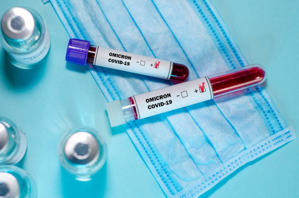 tubo de ensaio com amostra de sangue de teste omicron covid-19 positivo e frasco de vacina no laboratório médico. - ômicron - fotografias e filmes do acervo
