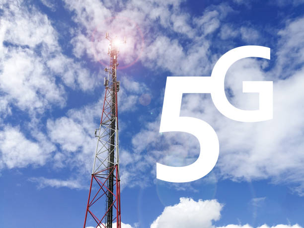 Text 5G and GSM repeater tower in front of blue cloudy sky stock photo