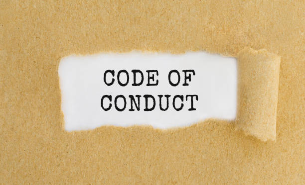 Text Code of Conduct appearing behind ripped brown paper. stock photo