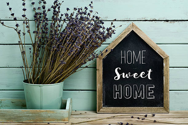 text home sweet home in a house-shaped signboard stock photo