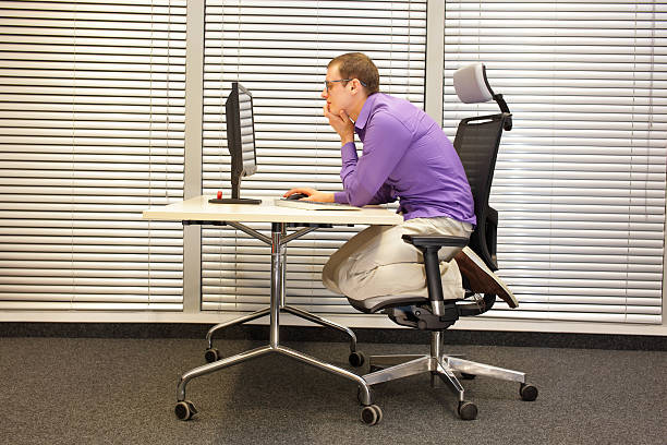 text neck - man in slouching position kneeling on  chair stock photo