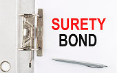 istock SURETY BOND text on the paper folder with pen. Business concept 1370951688