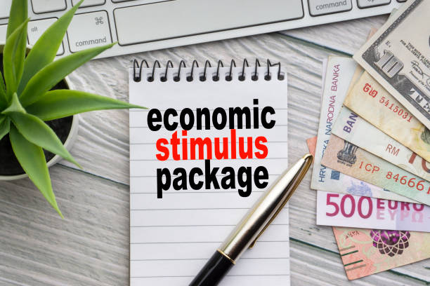 ECONOMIC STIMULUS PACKAGE text with notepad, keyboard, decorative vase, fountain pen, calculator and banknotes currency on wooden background ECONOMIC STIMULUS PACKAGE text with notepad, keyboard, decorative vase, fountain pen, calculator and banknotes currency on wooden background. Business and copy space concept congressional country club stock pictures, royalty-free photos & images