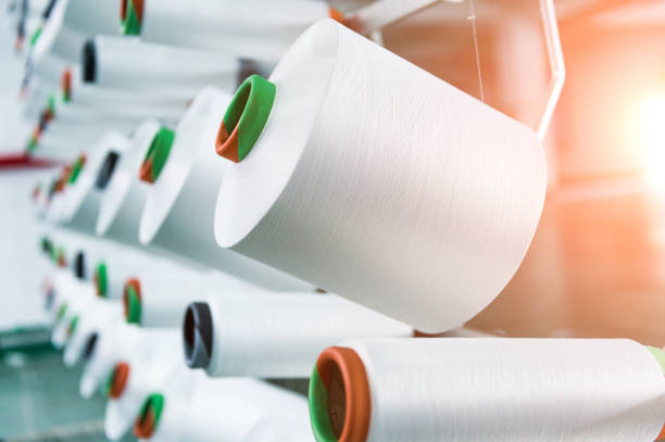 Textile industry - yarn spools on spinning machine stock photo