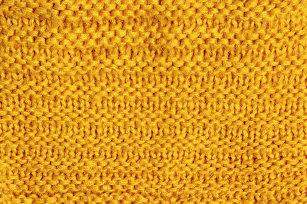 Texture, bright yellow knitted jersey close-up. Blank wool background for layouts. stock photo