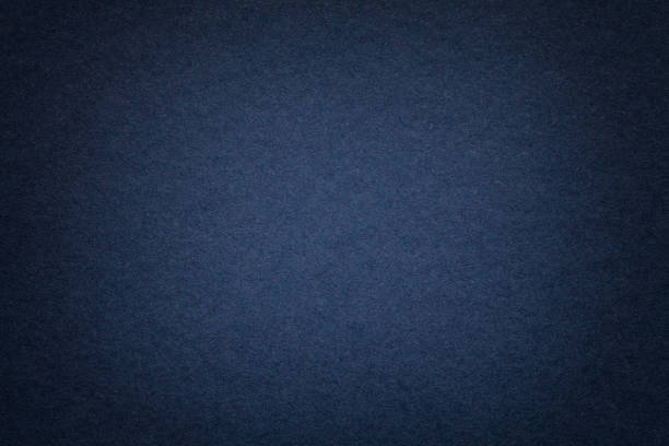 Texture of old navy blue paper background, closeup. Structure of dense cardboard. Texture of vintage dark denim paper background with vignette. Structure of dense navy blue kraft cardboard with frame. Felt gradient backdrop closeup. wrapping photos stock pictures, royalty-free photos & images
