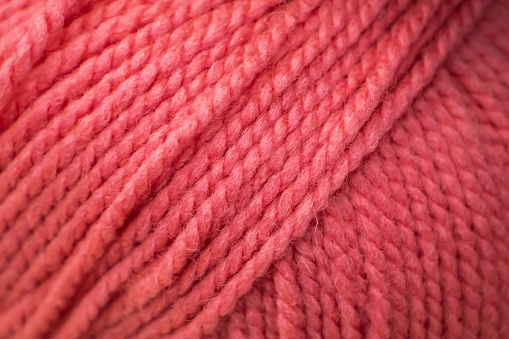 Texture of pink fluffy woolen threads for knitting closeup.