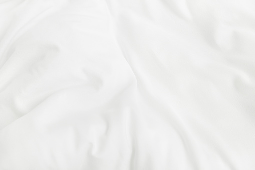 Texture of white blanket and bedding sheet with crumpled or messy in bedroom after wake up.