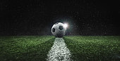 textured soccer game field in the rain at night -ball in the center, midfield
