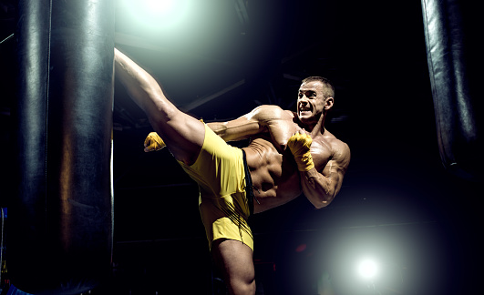 Thai Boxer Punch Kick By Punching Bag Black Bacground Horizontal Photo — стоковые фотографии и другие картинки Кикбоксинг - iStock