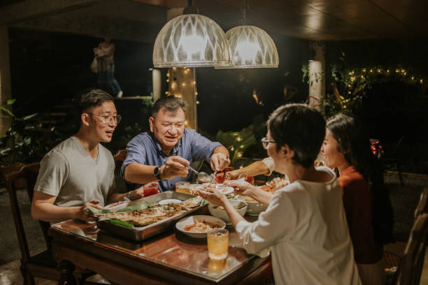 Thai daddy giving some food to wife beside family-stock photo stock photo