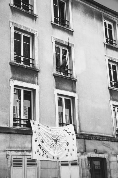 Thank you banner and French flag hanging on house in Parisian suburb to express gratitude and to support front line workers during coronavirus covid-19 outbreak. stock photo