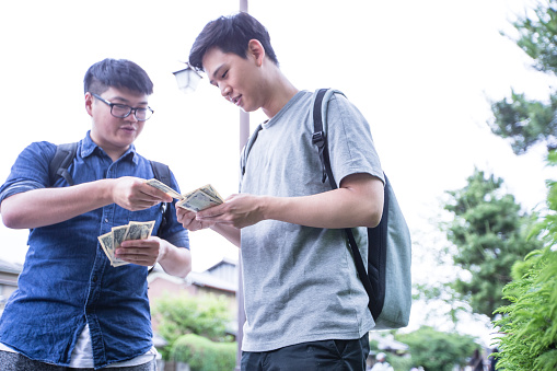 Student returning borrowed funds to his friend.