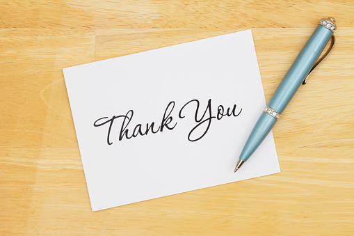 Thank you greeting card with a pen on a desk