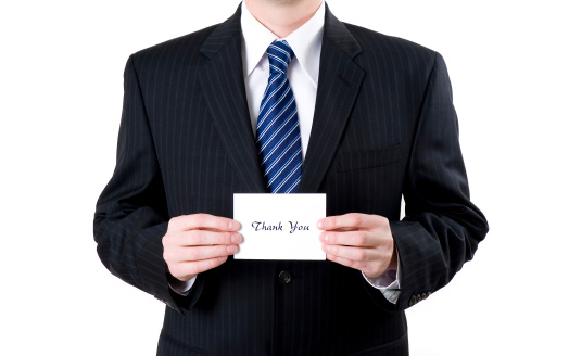 Business man holding a thank you note.