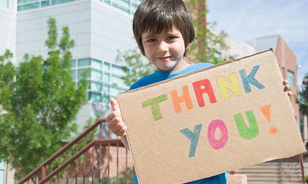 Thank You Sign Held By Happy Young Boy stock photo