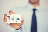 istock Thank you word on card hold by man 853375142