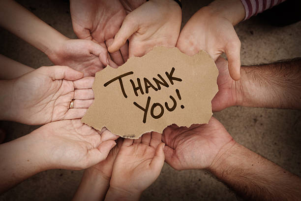 Thank You Written on Cardboard Being Held by Group stock photo