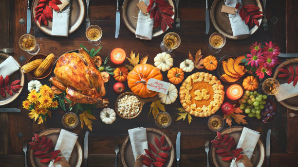 Thanksgiving celebration traditional dinner Thanksgiving celebration traditional dinner. Roasted turkey garnished with cranberries on a rustic style table decoraded with pumpkins, vegetables, pie, flowers and candles. Festive table setting turkey meat stock pictures, royalty-free photos & images