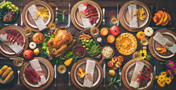 Thanksgiving celebration traditional dinner Thanksgiving celebration traditional dinner. Roasted turkey garnished with cranberries on a rustic style table decoraded with pumpkins, vegetables, pie, flowers and candles. Festive table setting thanksgiving food stock pictures, royalty-free photos & images