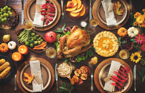 Thanksgiving celebration traditional dinner Thanksgiving celebration traditional dinner. Roasted turkey garnished with cranberries on a rustic style table decoraded with pumpkins, vegetables, pie, flowers and candles. Festive table setting thanksgiving food stock pictures, royalty-free photos & images